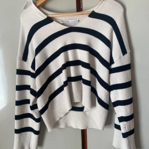 Randig stickad tröja från Bershka - Säljer en vit och svart randig tröja från Bershka. Tröjan har lång ärm, bred rund halsringning och är stickad i mjukt material. Perfekt för en avslappnad och trendig look.