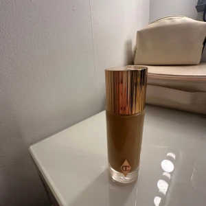 Charlotte Tilbury foundation med guldig kork - PRIS KAN DISKUTERAS! Flytande foundation från Charlotte Tilbury i en glasflaska med guldig kork. Nyansen är 5.5 Warm. Perfekt för en jämn och naturlig bas. Snygg och lyxig design som passar i sminkväskan.