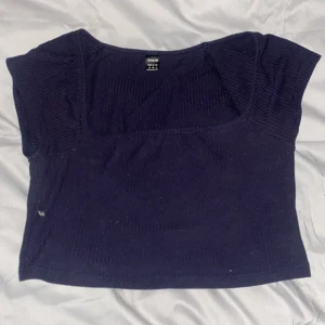 Blå croppad topp från Shein - En blå croppad topp från Shein med ribbad struktur och korta ärmar. Toppen har en fyrkantig ringning och är tillverkad i ett stretchigt material som sitter snyggt på kroppen.