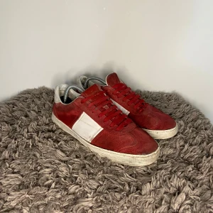Valentino Flycrews - Säljer ett par snygga röda och vita sneakers från Valentino med klassisk design. Skorna har röd mocka och vita detaljer i skinn, samt röda snören och rund tå. Perfekta för dig som vill sticka ut med stilrena och exklusiva sneakers.