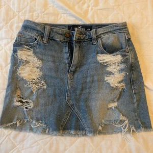 Blå jeanskjol från Hollister - Säljer en ljusblå lowwaist hollister jeanskjol i storlek 24. Inga tecken på användning elelr defekter🥰😊