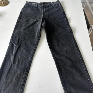 Svarta loose fit jeans från Jack & Jones - Säljer ett par svarta jeans från Jack & Jones i loose fit-modell i storlek 164/14y. Jeansen har klassisk femficksdesign, normal midja och raka ben. Perfekta för dig som gillar en avslappnad stil och vill ha gott om rörelseutrymme.