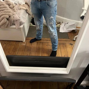 Replay jeans - Snygga blå jeans med en lätt slitning och normal passform. De har en klassisk femficksdesign och är perfekta för en avslappnad stil. Midjan är midwaist och byxorna har en dragkedja.