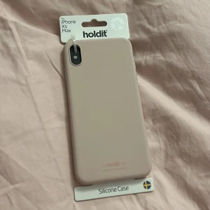 Beige silikonfodral för iPhone Xs Max från Holdit - Snyggt och stilrent beige silikonfodral från Holdit, designat för iPhone Xs Max. Fodralet är en del av Holdits Essential-kollektion och erbjuder ett bra skydd för din telefon. Perfekt för dig som vill ha ett enkelt och elegant skydd.