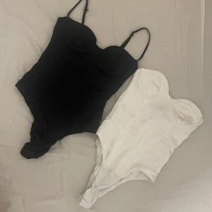 Svart och vit korsett från Zara - Säljer två snygga korsetter-bodysuit från Zara i svart och vit. Passar små byst som A70 eller mindre. Den vita har tyvärr tappat bandet så kommer att vara billigare. Svart: 50kr, Vit:40kr. Köp två för 80kr i den här annonsen för att få dem samfraktad.