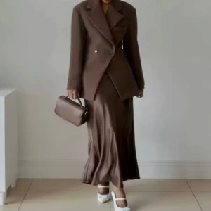 Brun kavaj - Elegant brun kavaj med dubbelknäppning och klassisk krage. Perfekt för en stilren look, oavsett om du bär den med kjol eller byxor. Kavajen har en tidlös design som passar till många tillfällen.