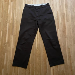 Dickies 874 Original - Bruna byxor från Dickies. De har en rak passform och är tillverkade i ett slitstarkt material. Perfekta för en avslappnad stil.