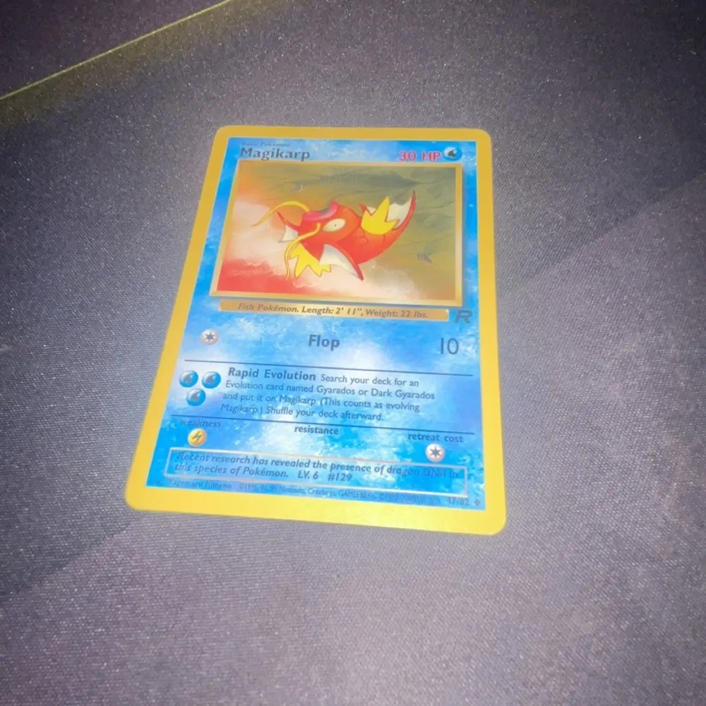 Säljer ett Magikarp Pokémonkort med blå ram och klassisk design. Kortet har en bild av Magikarp i mitten och text med dess egenskaper och attacker, den har lite white spots på sidorna. Perfekt för samlare eller Pokémonfans!. Muu.