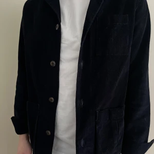 Blå overshirt från John Henric - Snygg blå overshirt från John Henric med knappar framtill och flera praktiska fickor. Perfekt för lager-på-lager-stil och passar bra till både vardag och mer uppklädda tillfällen.