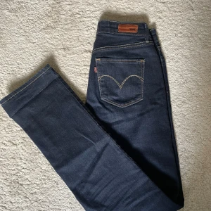 Mörkblå lågmidjade Levi’s jeans - Snygga mörkblå jeans från Levi's med klassisk passform. De har en rak stil och är perfekta för en avslappnad look. Jeansen har fem fickor och en knappgylf. De är i nyskick och har inga tecken på användning.