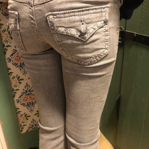 Grå jeans från Gina tricot med broderade fickor - Snygga grå jeans med broderade detaljer på bakfickorna. Perfekta för en avslappnad stil med en touch av det lilla extra.