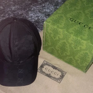 Svart keps från Gucci - Snygg svart keps från Gucci med det klassiska GG-mönstret. Kepsen har en justerbar baksida i mesh för bättre ventilation och passform. Perfekt för en stilren look.