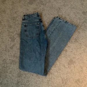 Blå jeans med regular wide fit - Snygga blå jeans med en regular wide passform. De har en klassisk femficksdesign och knappgylf. Högmidjade. Använda fåtal gånger. Nypris 600kr. 