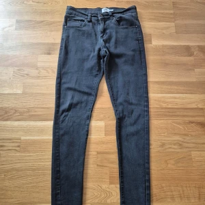 Grå jeansbyxor - Snygga grå jeansbyxor med en tight passform. De har klassiska femficksdetaljer och en smal siluett som passar perfekt för en stilren look. Perfekta för dig som gillar en modern och enkel stil.