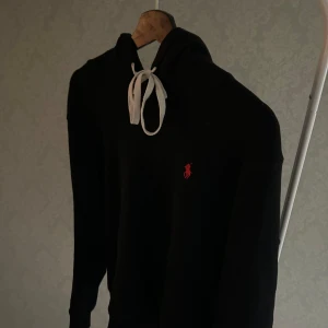 Svart hoodie från Ralph lauren  - Snygg svart hoodie med vit snörre och en liten röd logotyp på bröstet. Från Ralph lauren 