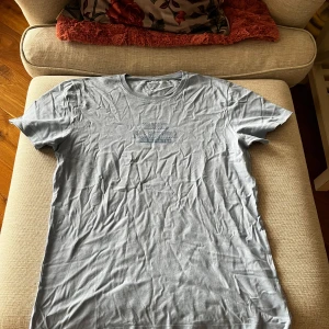 Grå t-shirt från DeFacto - Säljer en grå t-shirt från DeFacto i storlek M. Den har en slim fit passform och är kortärmad. Perfekt för en avslappnad stil.