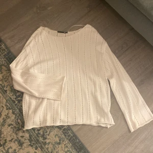 Vit långärmad tröja stickad - Säljer en stilren vit tröja med lång ärm och ett subtilt randigt mönster. Tröjan har en oversize passform och är tillverkad i ett lätt material.