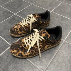 Leopardmönstrade sneakers - Sneakers med leopardmönster och vita snören.