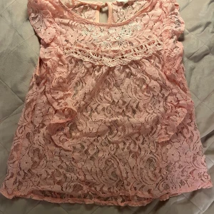 Rosa spets topp - Jätte söt rosa spets topp, passar bra med ett linne under då man ser igenom tröjan! Tröjan är köpt begagnad. Står storlek M men den passar bättre som en storlek s.