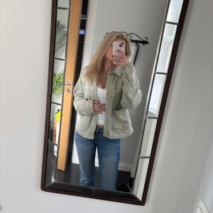 Grön  jeansjacka - Säljer en snygg ljusgrön jeansjacka med knappar framtill. Jackan har en avslappnad passform och långa ärmar. Perfekt för vår och sommar!