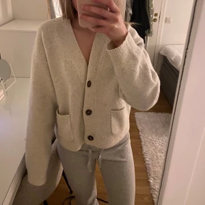 Beige kofta med knappar - Mysig beige kofta med stora knappar framtill och två fickor. Perfekt för kyliga dagar. Köpt här på Plick men har inte kommit till användning så säljer den vidare. 
