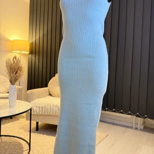 Ljusblå ribbad långklänning - Snygg ljusblå ribbad långklänning med hög hals. Perfekt för en stilren look. Klänningen har en tight passform som framhäver figuren. Passar perfekt som oversize modell (s/m/l storlek). Jag rekommenderar den varmt.🌸👌