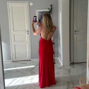 Röd långklänning från Zara - Snygg och oanvänd röd långklänning från Zara med smala axelband och öppen rygg. Perfekt för en elegant kväll. Ordninarie pris 1000 kr, jag säljer den för 500 kr :) 