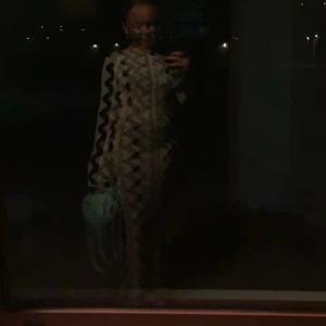 Beige och svart klänning med vågigt mönster - Säljer denna otroligt sköna och snygga klänningen från nakd. Den är öppen vid midjan på båda sidorna 