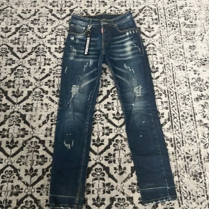 Blå jeans från Dsquared2 - Snygga blå jeans från Dsquared2 med slitna detaljer och en cool tvätt. De har en normal passform och är perfekta för en trendig look. Märkeslogga synlig på framsidan.