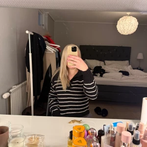 Svart och vit randig tröja - Säljer en svart och vit randig tröja med v-ringning. Tröjan har långa ärmar och ribbade muddar. 