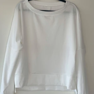 Vitt mjukis sett med tröja och byxor  - Snyggt sett med vita byxor med resårmidja för en bekväm passform och vit collage tröja. Perfekta för en stilren look. Byxorna har en rak design och är tillverkade i ett lätt material.