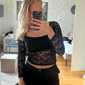 Svart spetsblus - Snygg festlig spetstopp, finns ett undertyg runt bysten, storlek 36  