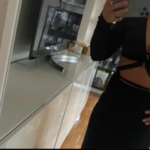 Svart långärmad knytblus - Snygg svart långärmad blus med knytning framtill. Perfekt för en stilren look. Blusen har en åtsittande passform och är tillverkad i ett mjukt material. Aldrig använd 