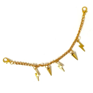Guldfärgat accessoarsmycke - Guldfärgat handgjort accessoarsmycke med hängande blixtar och spikar ⚡️Häng på väskan eller byxorna för en cool touch på outfiten ⚡️