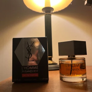 L'Homme Eau de Parfum från Yves Saint Laurent - Elegant och maskulin doft från Yves Saint Laurent, L'Homme Eau de Parfum. Flaskan har en stilren design med en sexkantig metallkork och den ikoniska YSL-loggan. Innehåller 60 ml av en sofistikerad doft som passar perfekt för den moderna mannen.