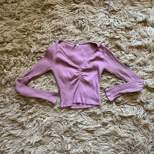 Rosa ribbad topp - rosa ribbad topp med v-ringning. Väl använd men i fint skick