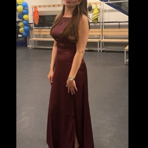 Vinröd långklänning i satin - Säljer min fina Balklänning🙌 använd 1 gång så är mycket bra i skick. Hör av er vid andra frågor.