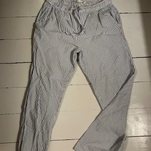 Randiga byxor  - Supersköna randiga byxor i blått och vitt med elastisk midja, storlek M. Byxorna har en loose passform och är luftiga och bekväma. Supersköna att ha på sommaren! Dock har de inte kommit till användning då de är för korta för mig🤍🩵