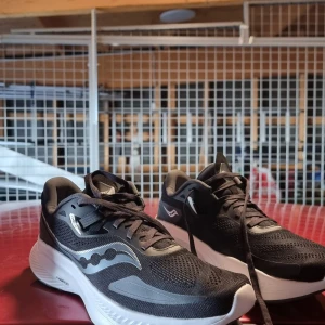 Svarta löparskor från Saucony - Säljer ett par svarta DAM löparskor från Saucony, Köpta för flera år sen, ALDRIG använda..  En sportig look med märkets logotyp på sidan. Perfekta för löpning, träning eller vardagsskor. NYPRIS 1699