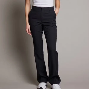 Svarta kostymbyxor - Eleganta svarta kostymbyxor med hög midja och bootcut-stil. Perfekta för en stilren look. Byxorna har en klassisk design med dragkedja och knappar framtill.