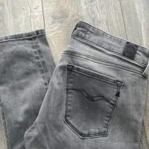 Grå jeans från Replay - Snygga grå jeans från Replay med en stilren design. De har en klassisk femficksmodell och knappgylf. Perfekta för en avslappnad look. Mycket fin grå färg nu till våren! 