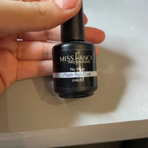 Miss Fancy Flash Top Coat - Miss Fancy Professional No Wipe Flash Top Coat för UV & LED. Denna top coat har en glittrig finish som ger naglarna en extra glansig look. Perfekt för att försegla och skydda din manikyr med en glittrande touch. Oanvänd