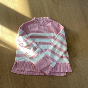Rosa och vit randig tröja från Gina Tricot - Säljer en söt rosa och vit randig tröja från Gina Tricot. Tröjan har långa ärmar och ribbade detaljer vid hals och nederkant. Perfekt för en avslappnad stil. 🌸