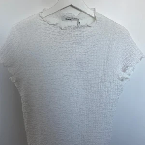 Vit T-shirt med struktur  - Säljer en T-shirt från Kappahl som aldrig är använd med lappen kvar, endast provad🩷 Fin t shirt som passar till det mesta. Priset går att diskutera 