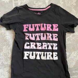 Lila barntröja med citatet “Future Future Create the Future” – strl 134/140 - Tuff och trendig lila tröja i storlek 134/140 med citatet “Future Future Create the Future” framtill. En cool statement-tröja som passar perfekt till skola, vardag eller chill hemma. Tröjan är i bra skick – inga fläckar eller hål, bara lite använd och redo för nästa ägare.  Mjuk och skön kvalitet som är behaglig att ha på sig. Snygg att matcha med jeans, tights eller shorts. Passar både tjejer och killar som gillar färg och att uttrycka sig genom kläder.  Kommer från ett djur- och rökfritt hem.