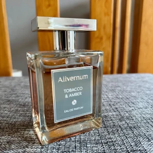 Allvernum Tobacco & Amber EDP - Upptäck Allvernum Tobacco & Amber, en Eau de Parfum med en rik och djup doftprofil. Toppnoter av kryddnejlika, körsbär och pimento ger en kryddig och söt inledning. Hjärtat består av tonkaböna, immortelle och tobak, medan basen avrundas med bärnsten och vanilj. Perfekt för den som älskar en komplex och varm doft. Ca 85ml kvar. Lådan medföljer ej.