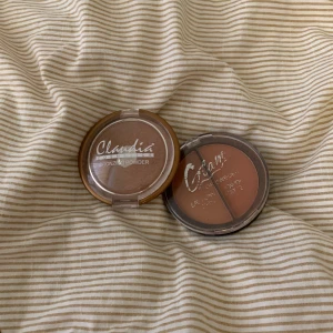 Bronzer och rouge från Claudia och Glam - Två sminkprodukter: en bronzer från Claudia i en rund förpackning med genomskinligt lock och en rouge från Glam i en liknande förpackning. Perfekt för att ge ansiktet en solkysst look och fräsch färg.