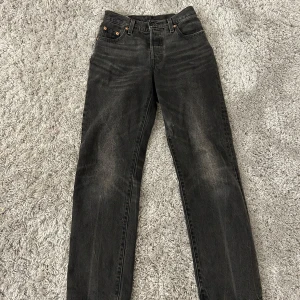 Svarta Levis jeans W23 L30 - Snygga svarta jeans från Levis med knappgylf. Byxorna har en rak passform. Storlek W23 L30 Nypris: 1199 (säljer åt syrran)