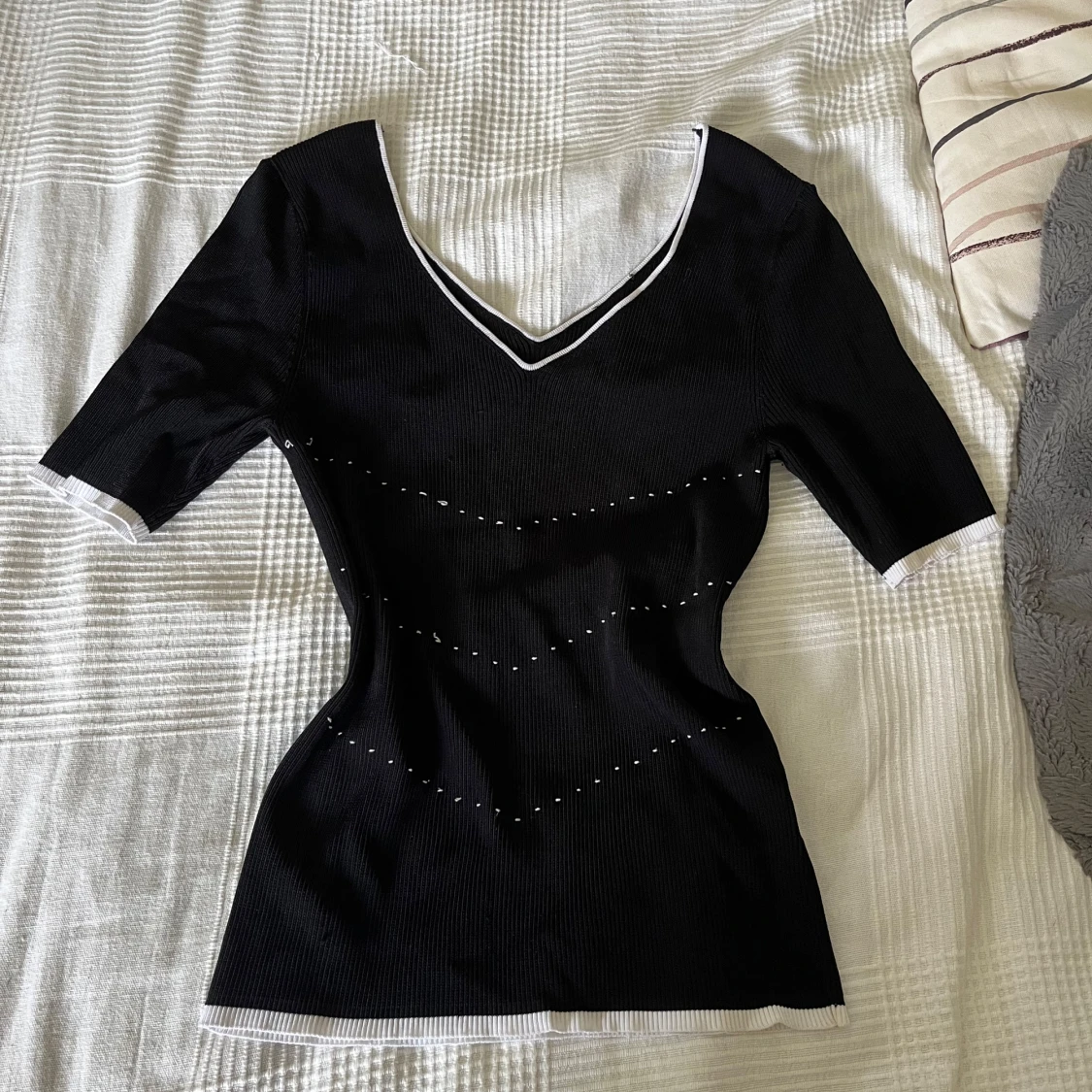 Svart ribbad topp med vita detaljer - 1