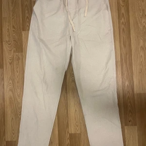 Beiga linnebyxor  - Från Melker Ahlqvist kollektion. Snygga och luftiga beiga linnebyxor med dragsko i midjan. Byxorna har rak passform och är perfekta för varma dagar. Aldrig använda och köptes förra sommaren 